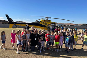 Students outside in front of a helicopter